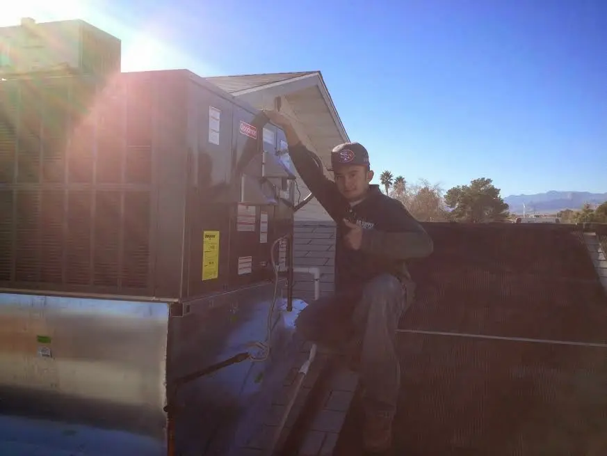 HVAC technician performing AC Tune-Up on a rooftop unit in Little Falls
